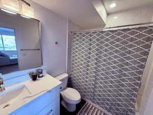 Bathroom with curtained shower, a sink, and toilet