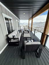 Snow covered deck with outdoor lounge area and a mountain view