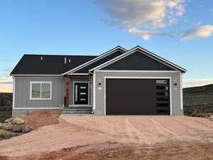 View of front facade featuring driveway, a garage, and board and batten siding