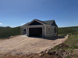 View of front facade with driveway, a garage, and a mountain view