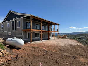 Back of property featuring a balcony and a mountain view