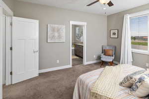 Bedroom with carpet flooring, connected bathroom, and ceiling fan