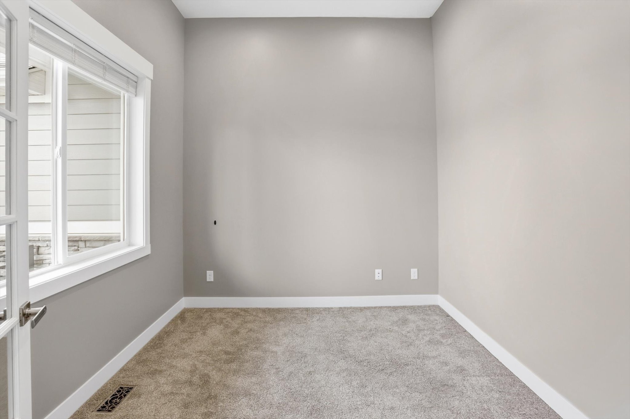 Room featuring neutral-toned walls, white baseboards, and plush gray carpeting