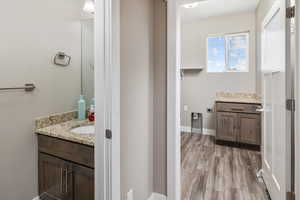 Bathroom with vanity with extensive cabinet space and hardwood / wood-style floors