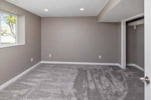 Unfurnished bedroom featuring dark colored carpet and a closet