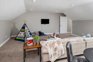 Carpeted living room featuring a textured ceiling and lofted ceiling