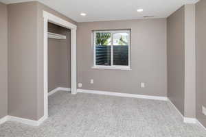 Unfurnished bedroom with a closet and light carpet