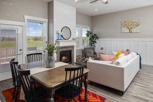 Dining area with light wood-type flooring, brick wall, and ceiling fan