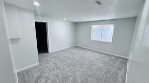 Empty room featuring carpet and a textured ceiling