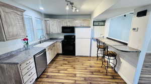 Kitchen with white refrigerator, dishwasher, range with electric cooktop, hardwood / wood-style flooring, and sink