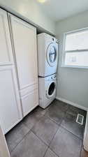 Laundry area featuring stacked washer and clothes dryer and tile floors