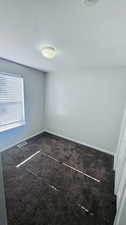 Carpeted empty room with a textured ceiling