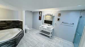 Full bathroom featuring tile flooring, large vanity, toilet, and a textured ceiling