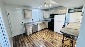 Kitchen with black appliances, sink, and wood-type flooring