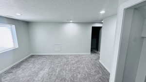 Spare room with a textured ceiling and carpet floors