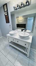 Bathroom featuring tile floors and dual vanity