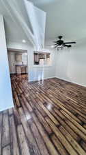 Unfurnished living room featuring dark hardwood / wood-style flooring, ceiling fan, and a textured ceiling