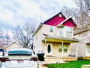 View of front of property featuring a front yard and covered porch