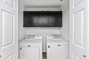 Washroom with washer and dryer and cabinets