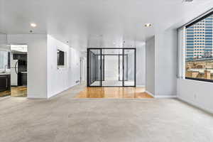 Unfurnished living room with light carpet and sink