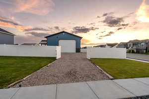 View of front of property featuring a garage and a lawn