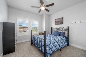 Carpeted bedroom featuring ceiling fan