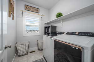 Laundry area featuring washer and dryer and light tile floors