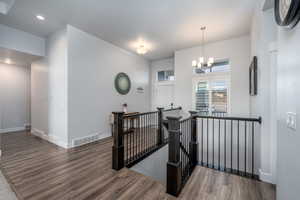 Hallway featuring a notable chandelier and dark wood-type flooring