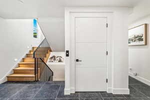 Staircase featuring dark tile floors