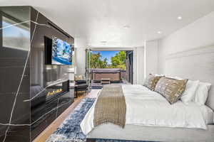 Bedroom with access to exterior and hardwood / wood-style flooring