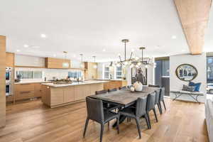 Dining area with a notable chandelier, sink, and light hardwood / wood-style floors