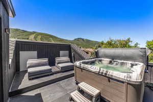 Wooden deck featuring a hot tub and a mountain view