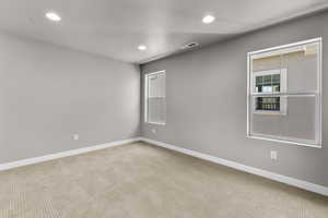 Carpeted spare room with a textured ceiling