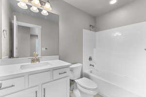 Full bathroom featuring washtub / shower combination, vanity, and toilet