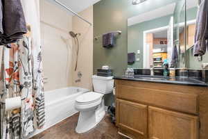 Full bathroom with shower / bathtub combination with curtain, tile flooring, vanity, and toilet