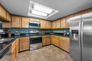 Kitchen featuring sink, light tile floors, and stainless steel appliances