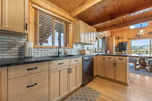 Kitchen featuring tasteful backsplash, wooden ceiling, beam ceiling, light wood-type flooring, and sink