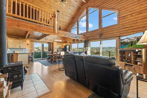 Living room with high vaulted ceiling, light wood-type flooring, and wooden ceiling