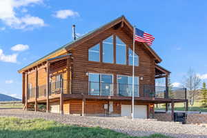 Back of house with a deck and a garage