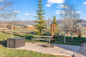 Surrounding community with a yard, a mountain view, and a patio