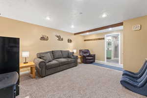 Living room featuring carpet and beam ceiling