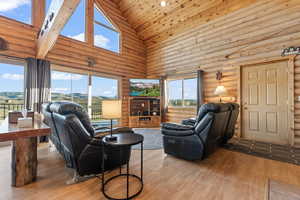 Living room with high vaulted ceiling, plenty of natural light, wooden ceiling, and wood-type flooring