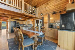 Dining area featuring plenty of natural light, log walls, and light hardwood / wood-style floors