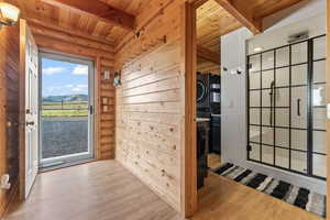 Interior space featuring beamed ceiling, light wood-type flooring, and wood ceiling