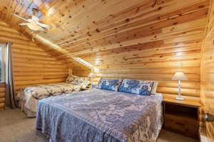 Carpeted bedroom with log walls, ceiling fan, and wood ceiling