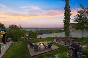 Yard at dusk featuring a fire pit with view of Antelope Island and the Great Salt Lake