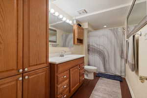 Bathroom featuring oversized vanity, toilet, and wood-type flooring