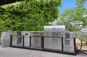 View of gazebo outdoor kitchen, a wooden deck, and area for grilling