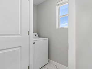 Laundry area with washer / clothes dryer and light tile floors