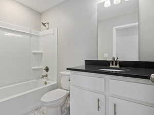 Full bathroom featuring tile floors, vanity with extensive cabinet space, toilet, and tub / shower combination